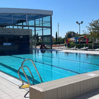 Piscine municipale de Decize avec le toit découvert qui donne un bassin extérieur avec transats et toboggan
