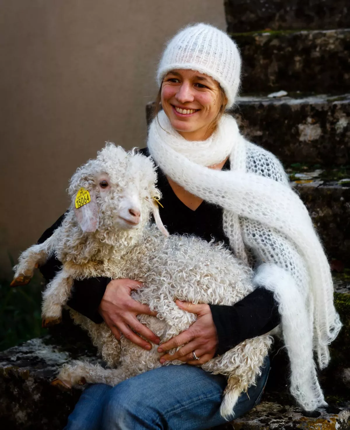 Emmanuelle de la Feé Mohair tenant un mouton dans les bras