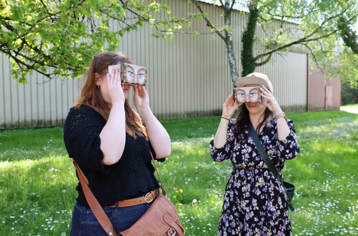 Deux personnes regardant dans un cardboard pendant la visite virtuelle La Machine